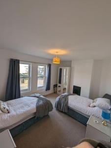 a bedroom with two beds and a window at New Fully equipped 2 bedroom house. Sleeps 6 in Brockhurst