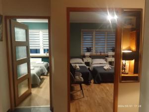 a room with two beds and a room with a mirror at Apartament Centrum Nowa Ruda in Nowa Ruda