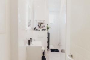 a white bathroom with a sink and a toilet at Ferienwohnung Zentrum Erding in Erding