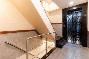 a staircase with a metal railing and a black door at Itsy By Treebo - Elegant in Mumbai