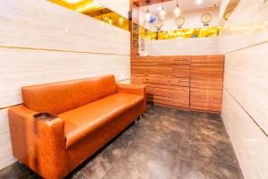 a brown leather chair in a room with wooden walls at Itsy By Treebo - Elegant in Mumbai