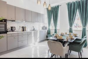 a kitchen with a dining table and green chairs at Ferienwohnung Zentrum Erding in Erding