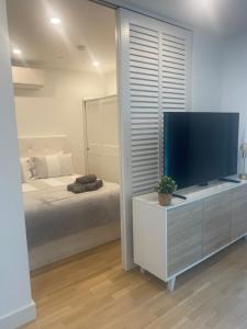 a bedroom with a large flat screen tv and a bed at CP Top floor luxury studio with spa and pool in Gibraltar