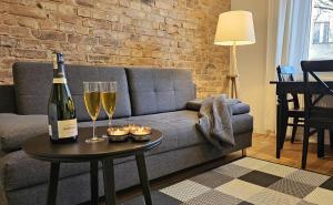 a living room with a couch and two glasses of wine at URBAN APARTMENTS PREMIUM No 2, FREE private parking, Self CHECK-IN in Chorzów +11 photos
