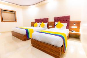 a bedroom with two beds with colorful sheets at Itsy Hotels Elegant in Mumbai