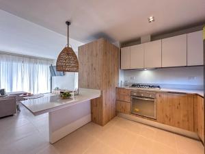 uma cozinha com armários brancos e uma bancada em Cozy and beautiful apartment at the beach em Punta Cana