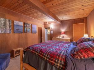 um quarto com uma cama num quarto de madeira em The Raccoon Shanty em Kings Beach