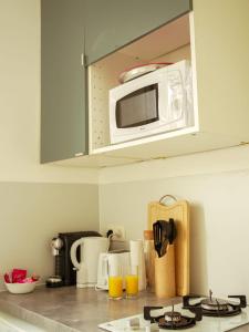 um balcão de cozinha com micro-ondas e sumo de laranja em FLOWER - Métro à 6 minute em Vanves