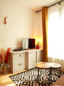uma sala de estar com uma televisão e uma mesa em FLOWER - Métro à 6 minute em Vanves