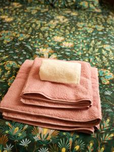 uma pilha de toalhas sentadas em cima de uma cama em FLOWER - Métro à 6 minute em Vanves