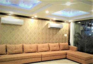 un sofá en una habitación con pared en GEETANJALI REGENCY en kolkata