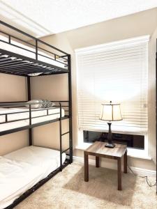 1 dormitorio con 2 literas y mesa con lámpara en Datu - Discover world with us, en Newport Beach