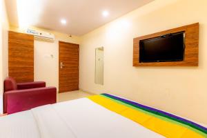a bedroom with a bed and a tv on the wall at Itsy Hotels Elegant in Mumbai +24 photos