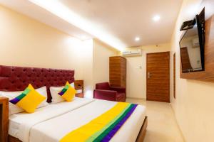 a hotel room with a bed and a television at Itsy Hotels Elegant in Mumbai