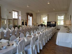 ein Zimmer voller Tische und Stühle mit weißer Bettwäsche in der Unterkunft Gutshof Kehnert - Pension & Ferienwohnungen in Kehnert