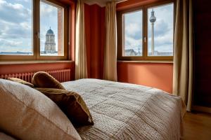 1 dormitorio con cama y ventanas con vistas en The Charming by Curt Suites en Berlín