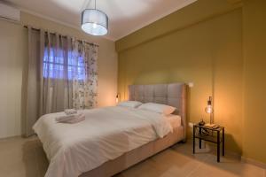 una camera da letto con un grande letto bianco e una finestra di Cosy Urban Escape a Alexandroupoli
