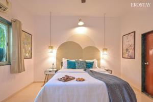 ein Schlafzimmer mit einem großen weißen Bett mit zwei Handtüchern darauf in der Unterkunft EKOSTAY - Omega Villa in Igatpuri