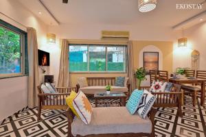 ein Wohnzimmer mit Stühlen und einem Tisch in der Unterkunft EKOSTAY - Omega Villa in Igatpuri