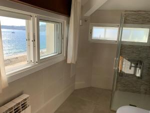 a bathroom with a shower and a window at Hotel Playa in Cangas de Morrazo