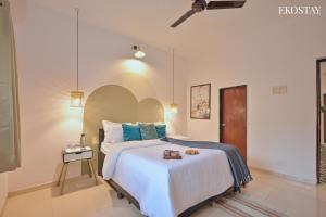 a bedroom with a large bed with blue pillows at EKOSTAY - Omega Villa in Igatpuri