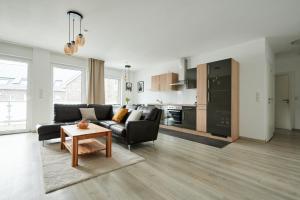 uma sala de estar com um sofá e uma mesa em Modernes Business Apartment in Weyhe Nähe Bremen em Weyhe