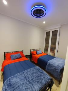 a bedroom with two beds and a blue ceiling at CENTRAL ROOM in Bilbao