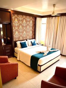 a bedroom with a large bed with blue pillows at GEETANJALI REGENCY in kolkata