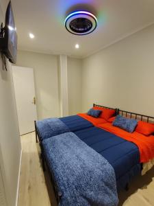 a bedroom with two beds with blue and red pillows at CENTRAL ROOM in Bilbao
