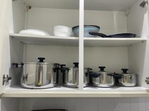 a kitchen shelf with pots and pans on it at VRY NICE PLACE London in London