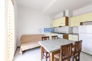 una cucina e una sala da pranzo con tavolo e sedie di Residence Adriatica a Lido di Jesolo