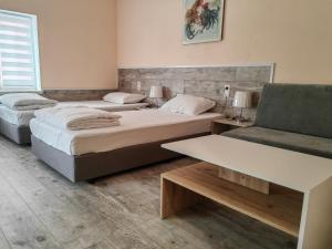 1 dormitorio con 2 camas, sofá y mesa en стаи за гости TODA en Troyan