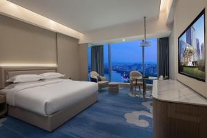 紹興市にあるWyndham Shaoxing Keqiaoのベッド1台、薄型テレビが備わるホテルルームです。
