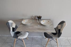 uma mesa de jantar com 2 cadeiras e uma mesa com copos em SWEET APPARTMENT em Patra