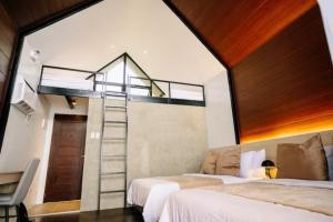 a bedroom with two beds and a spiral staircase at Grey Rock Mountain Cabin w/ Jacuzzi in Balamban