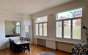 comedor con mesa y algunas ventanas en Paris Apartment 5-minute walk to tube station, en Les Lilas