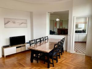 uma sala de jantar com uma mesa de madeira e cadeiras em Paris Apartment 5-minute walk to tube station em Les Lilas