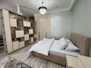 a bedroom with a large bed and a chandelier at Modern Spaces 2 in Yunusobod