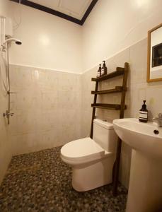 Łazienka z białą toaletą i umywalką w obiekcie General's Hideout Siargao w mieście General Luna