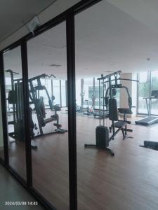 KejayanにあるTHE CABIN APARTMENT PATRALAND AMARTAのジム(複数のトレッドマシン、大きな窓付)