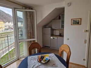 a kitchen and dining room with a table and a window at Apartment Traunkai Zauner Blick in Bad Ischl