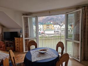 a dining room with a table and a large window at Apartment Traunkai Zauner Blick in Bad Ischl