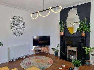 a living room with a television and a fireplace at Stylish three-bedroom house in central Lerwick in Lerwick