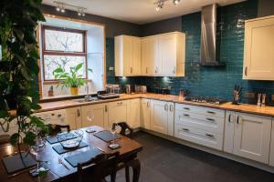 a kitchen with white cabinets and a wooden table with a dining room at Stylish three-bedroom house in central Lerwick in Lerwick