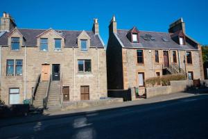 a large brick building with a staircase in front of a street at Stylish three-bedroom house in central Lerwick in Lerwick