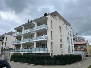 ein weißes Gebäude mit Balkon auf der Seite in der Unterkunft Ferienwohnung MiKa in Friedrichshafen