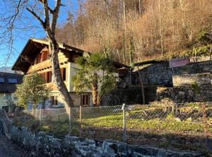 ein Haus mit einem Zaun davor in der Unterkunft Zauberhaftes Chalet mit Whirlpool, Berg & Seesicht in Brienz