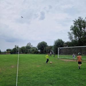 a boy is flying a kite on a soccer field at Mietwohnwagen in wulfener hals Fehmarn in Fehmarn