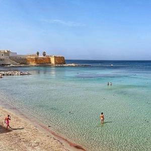 a group of people in the water on a beach at CasaNostra11 centro città e mare wifi 2 camere in Trapani +12 photos