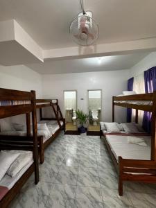 a room with four bunk beds and a potted plant at Mario's White House in Langi-langiban